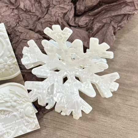 Snowflake-shaped hair clip on a textured surface