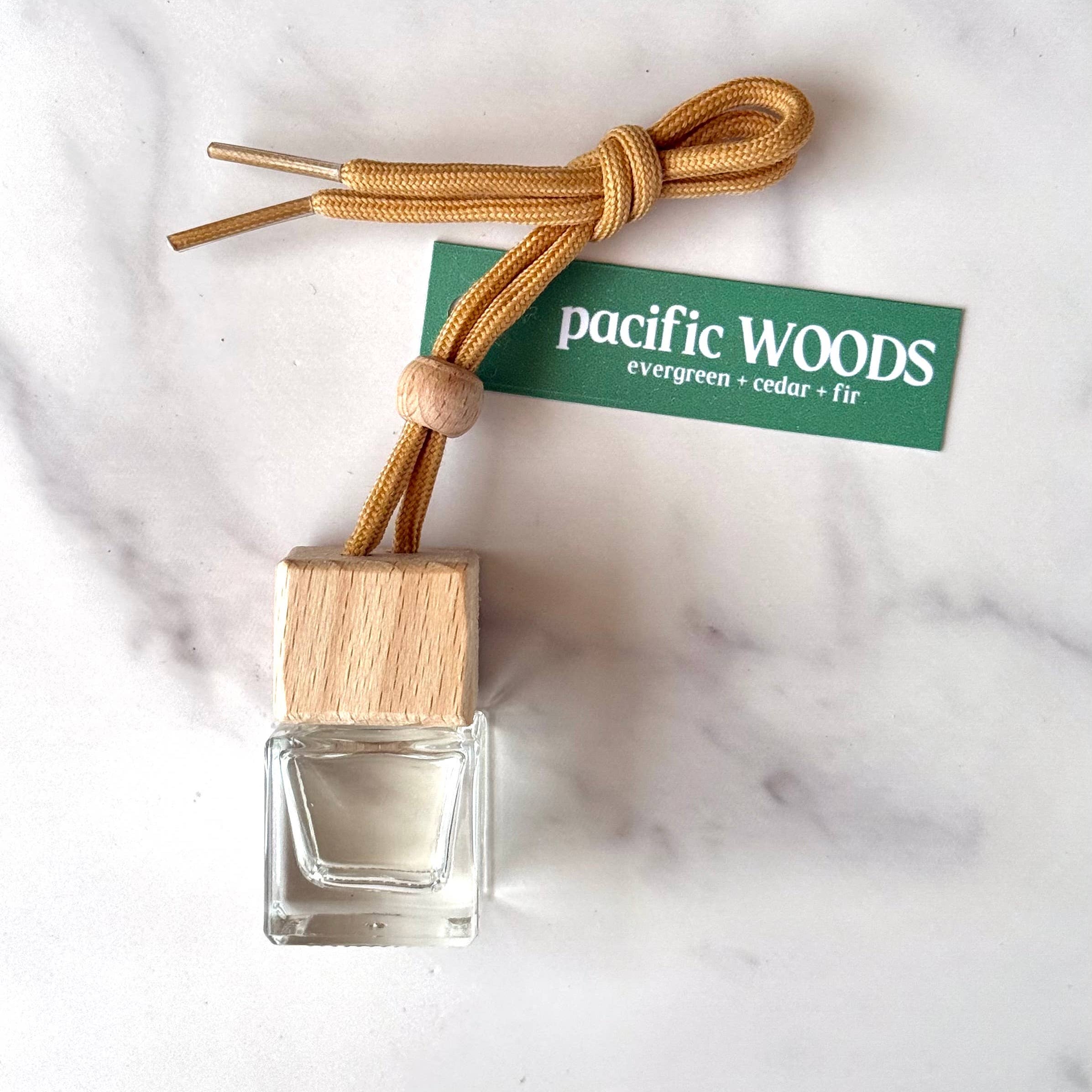 Small glass bottle with wooden cap and label on a marble surface