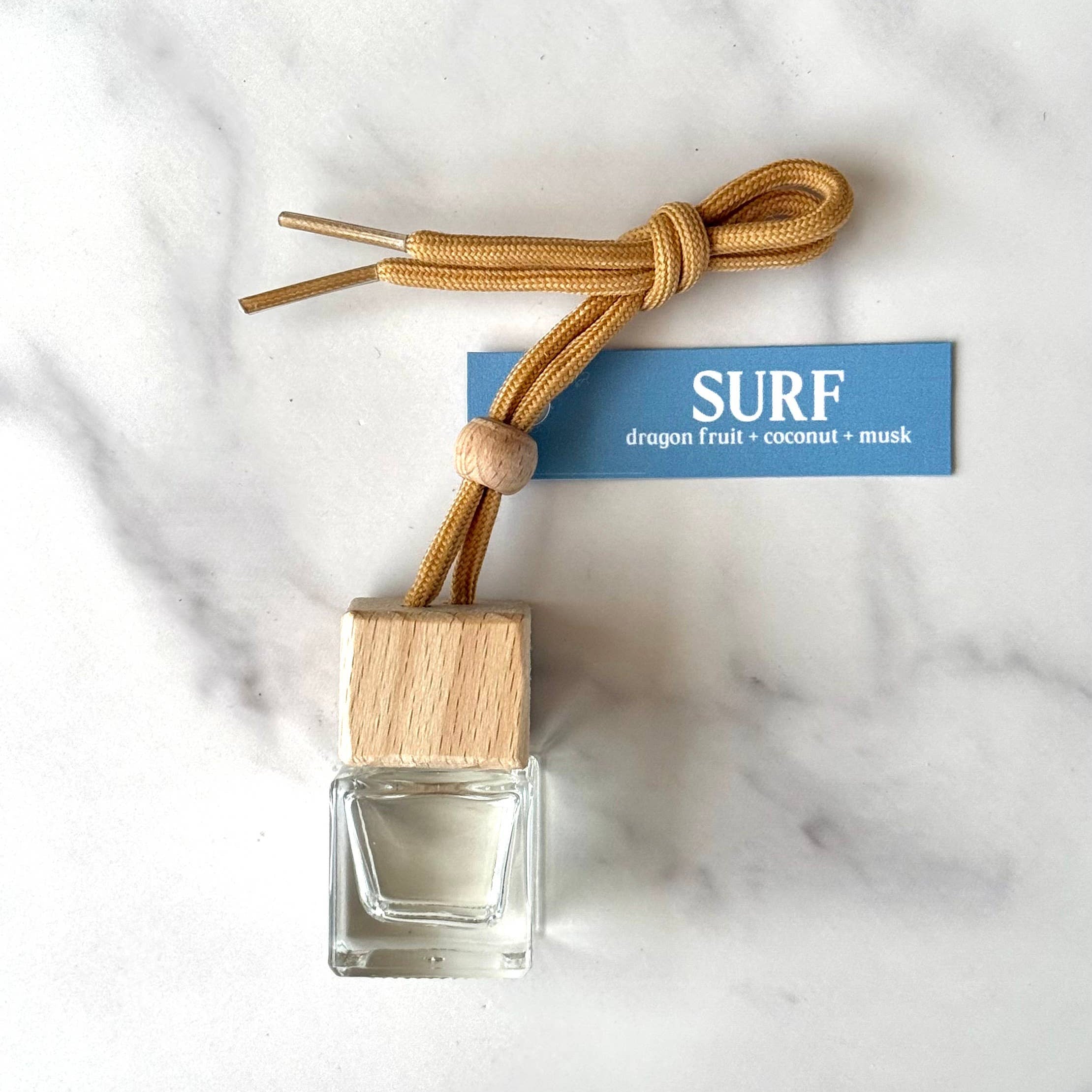diffuser bottle with wooden cap and rope on a marble surface