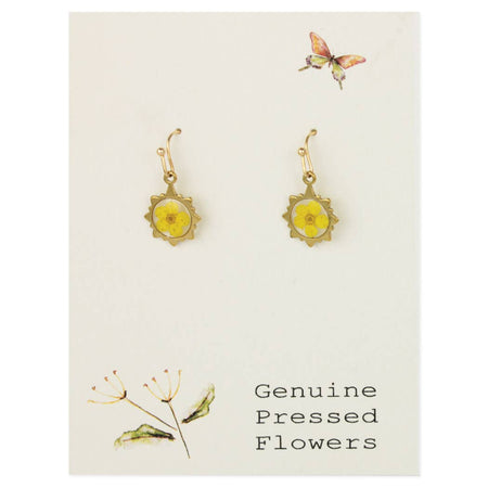 A pair of gold-tone dangle earrings with yellow pressed flowers in the center, displayed on a cream card with botanical illustrations and the text 'Genuine Pressed Flowers'.