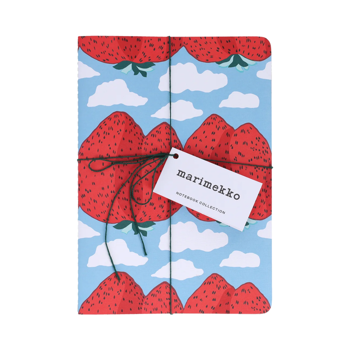A notebook from the marimekko Nutribook Collection wrapped in a dark green string with a white paper tag. The cover features a playful pattern of red strawberries and white clouds on a light blue background.