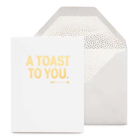 white card that reads " a toast to you" in gold foil with an arrow illustration