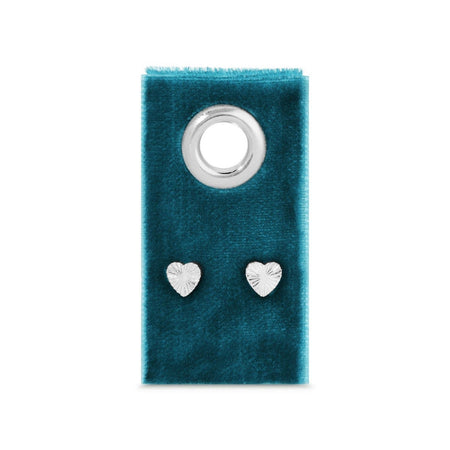 Heart-shaped silver earrings on a blue velvet card with a silver ring.