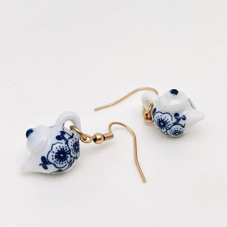 Teapot-shaped earrings with blue floral patterns on a white background