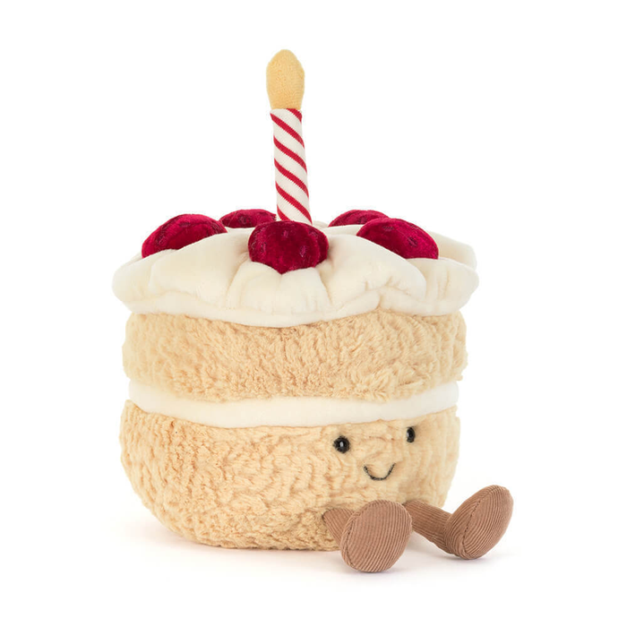 Plush toy resembling a birthday cake with candles on a white background