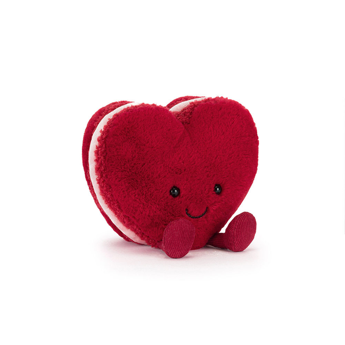 Red heart-shaped plush toy with a smiley face on a white background