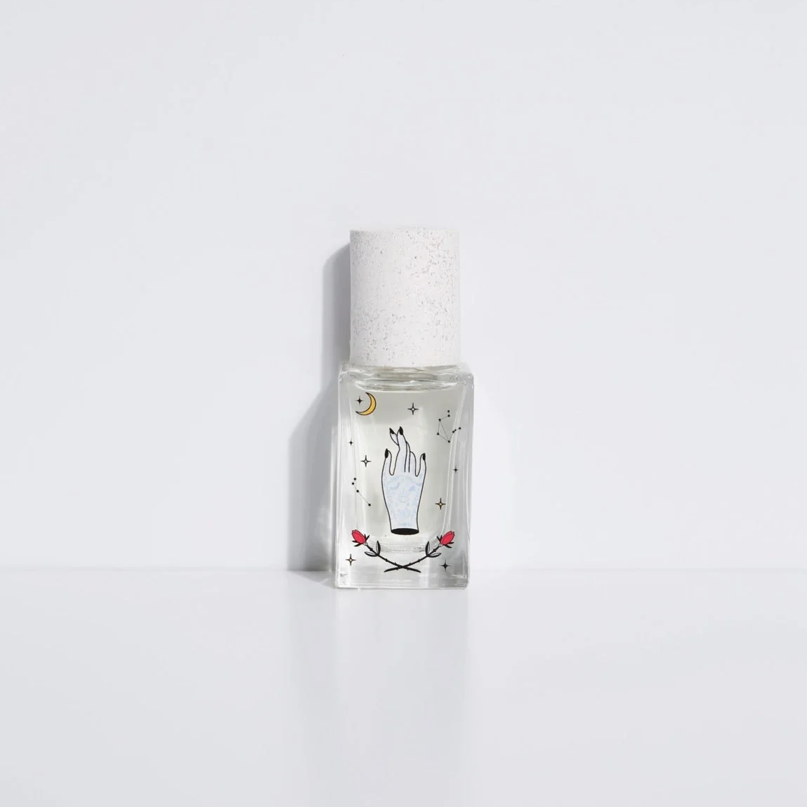Small glass bottle with decorative label on a white background