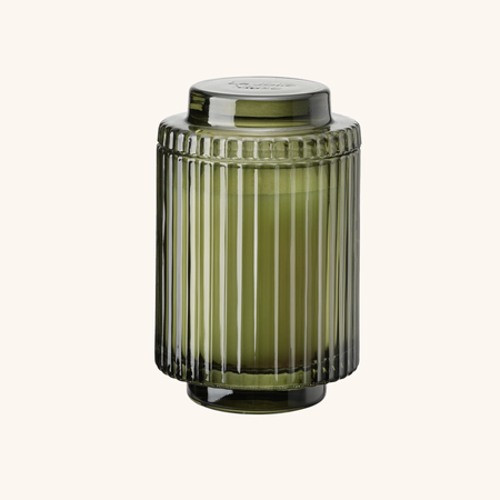 Green ribbed glass jar with a lid on a white background