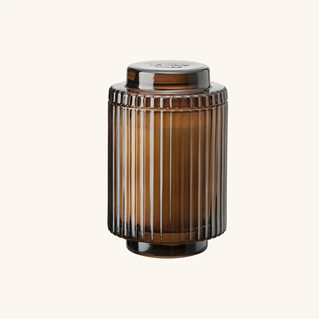 Brown ribbed glass jar with a lid on a white background