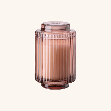 Pink glass jar with ribbed design on a white background