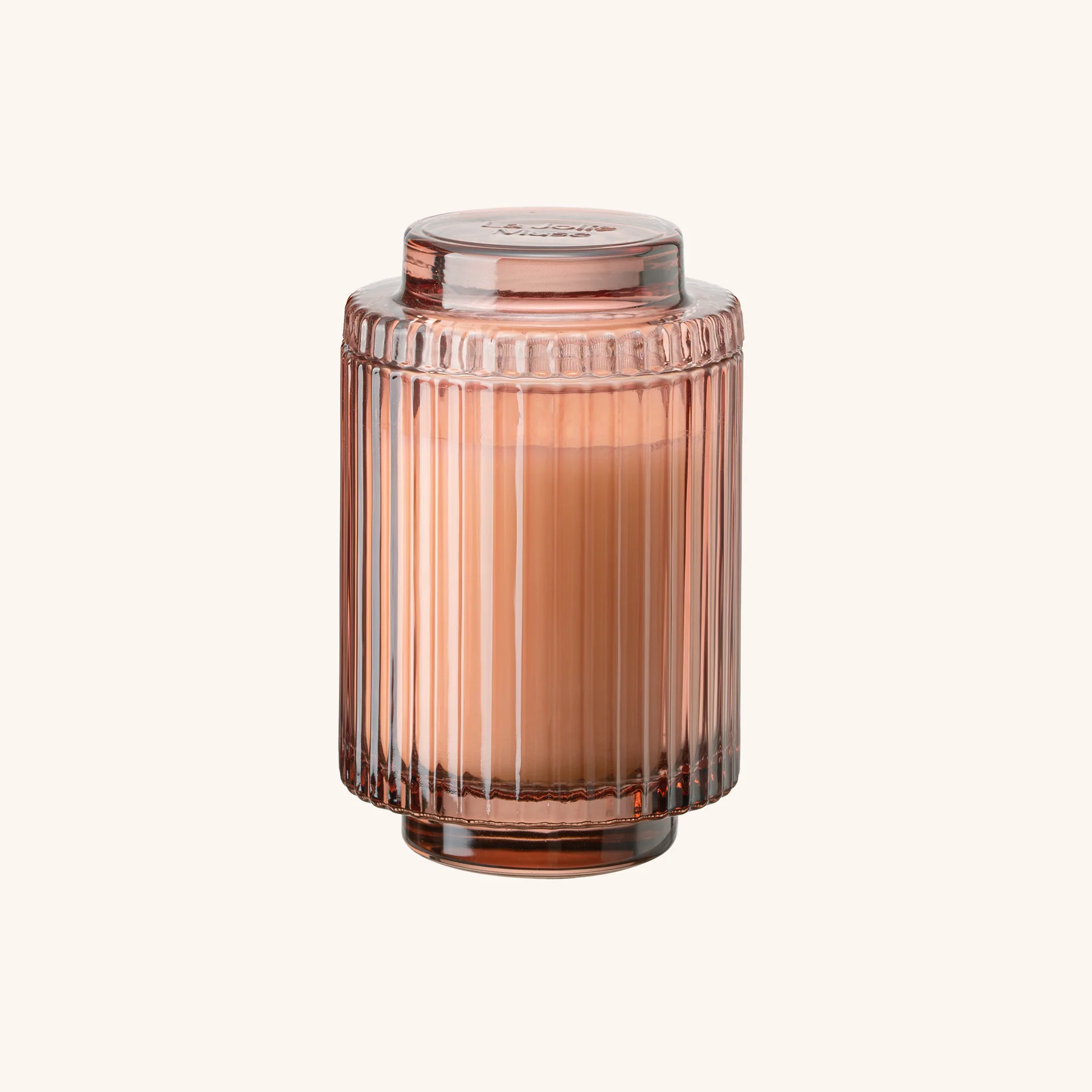 Rose gold glass candle holder with a candle inside on a white background
