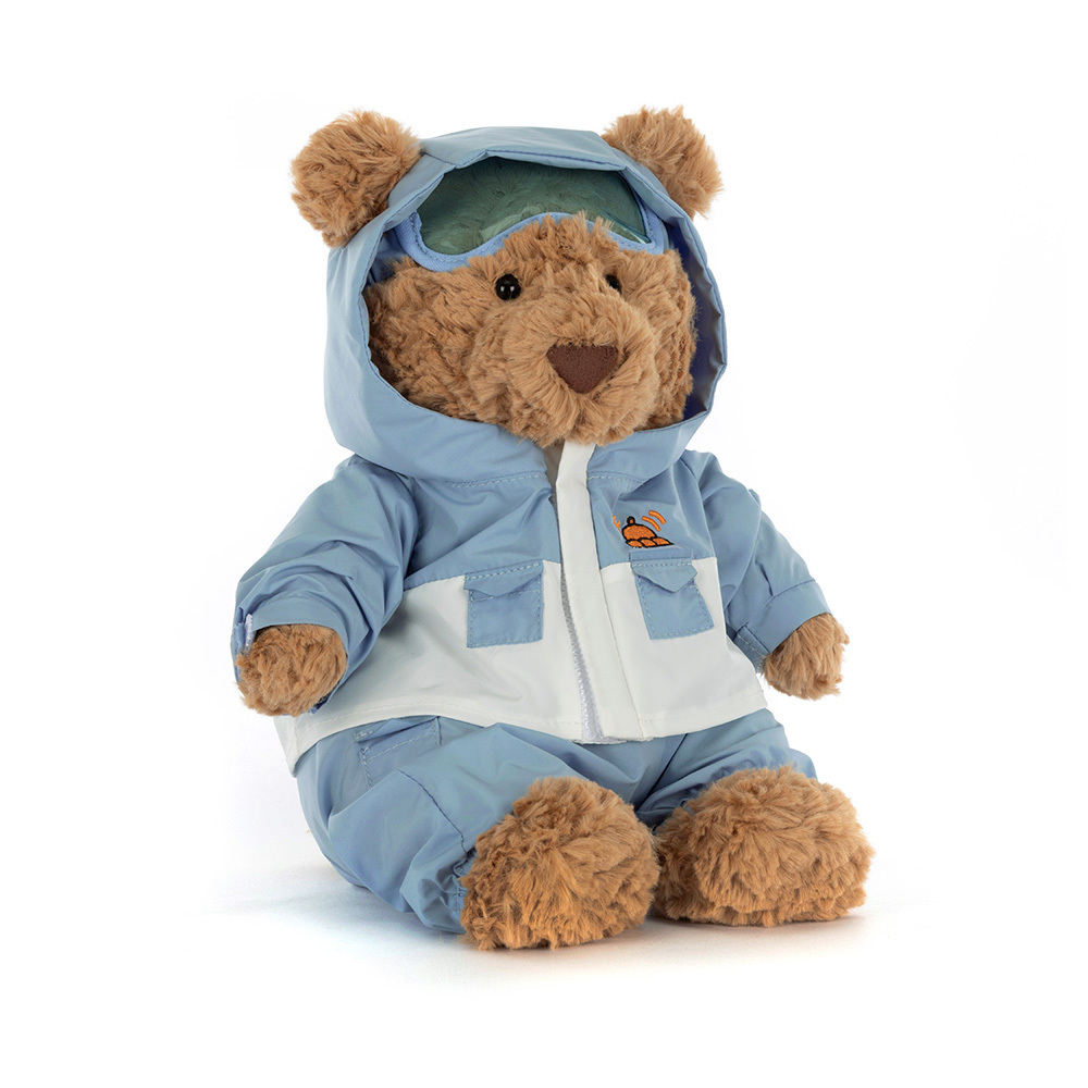 Stuffed teddy bear wearing a blue snowsuit with a hood on a white background