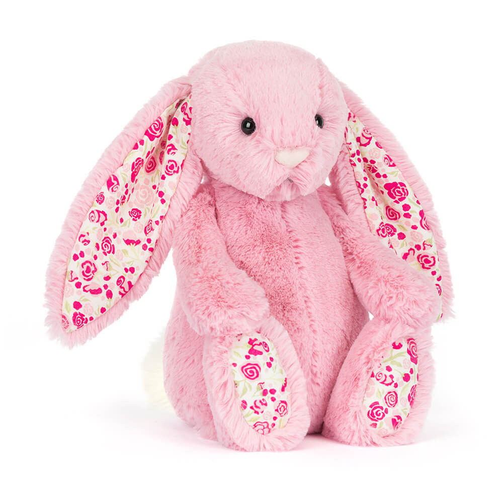 Pink bunny stuffie with floral pattern on inside of ears and bottom of feet on a white background