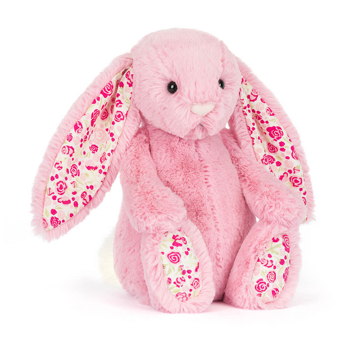 Pink bunny stuffie with floral pattern on inside of ears and bottom of feet on a white background