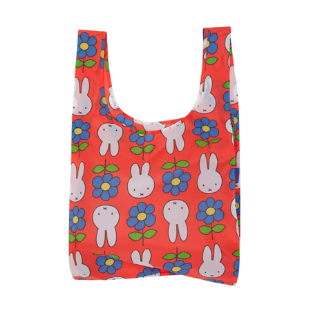 A red reusable shopping bag with a pattern of miffy, blue and green flowers on a white background.