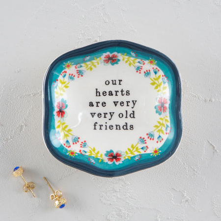 Mini trinket dish with the words "our hearts are very very old friends". White dish with a floral design and blue rim.