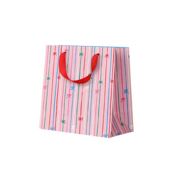 Colorful striped paper bag with red handles on a white background