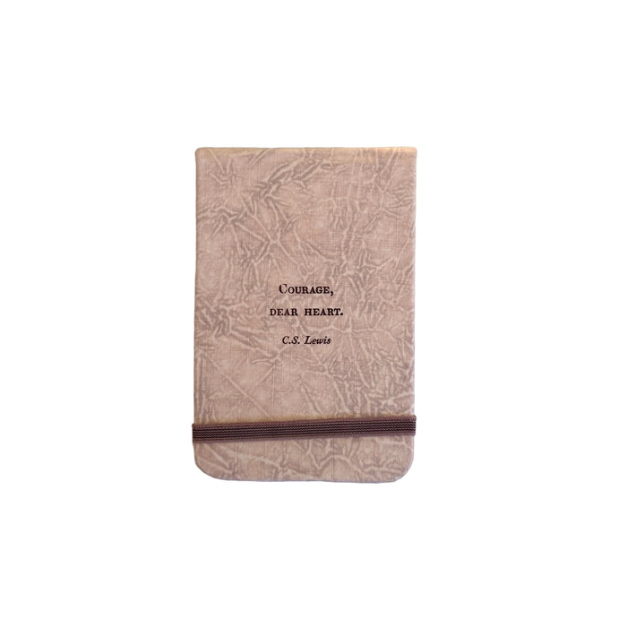 Small notebook with fabric cover and quote that reads "courage dear heart" on the front 