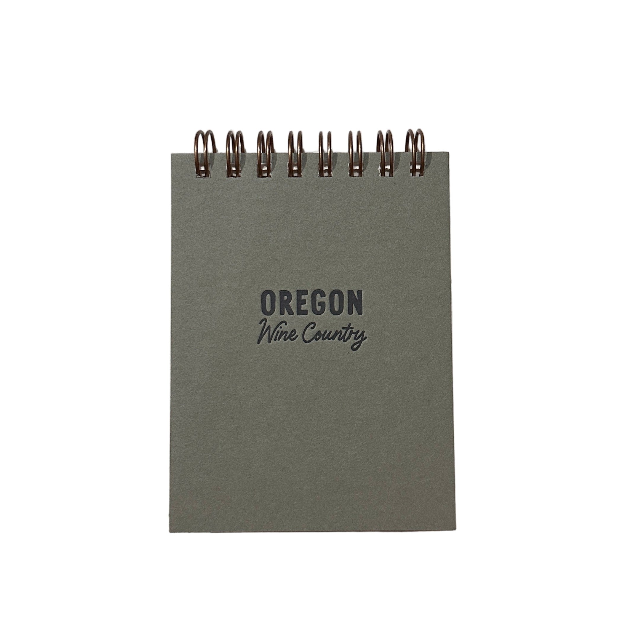 Small green notebook with 'Oregon Wine Country' text on a white surface