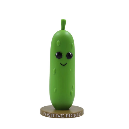 Green pickle figurine with a smiling face on a white background