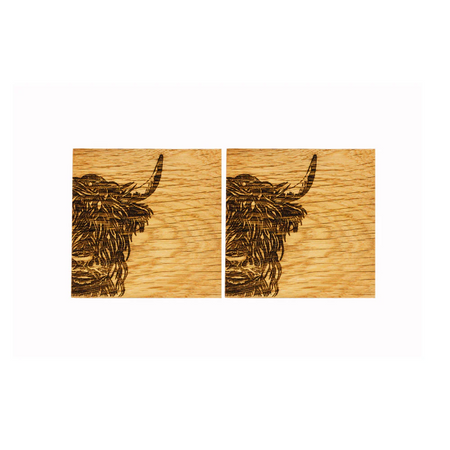 Two wooden coasters with engraved highland cow design on a white background