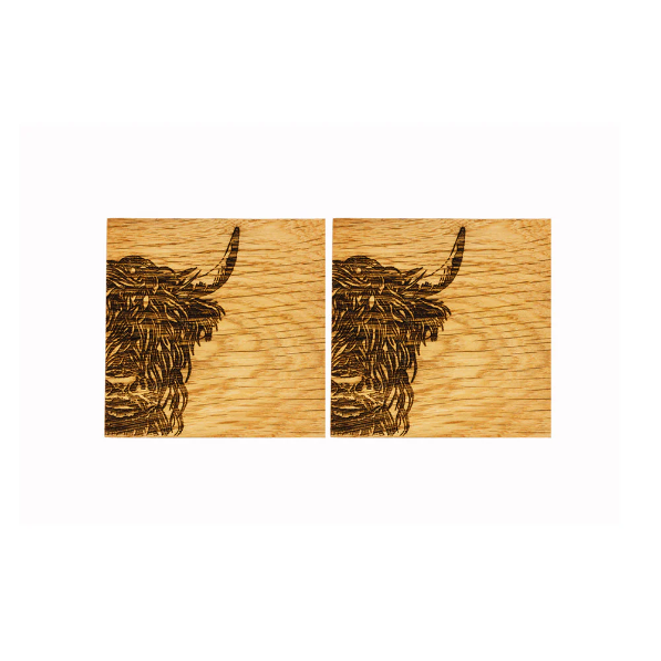 Two wooden coasters with engraved highland cow design on a white background
