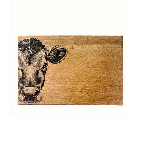 Wooden cutting board with a engraved cow face on a white background