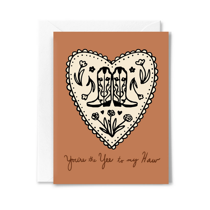 tan colored card with a white heart and cowgirl boots on the front with a white envelope