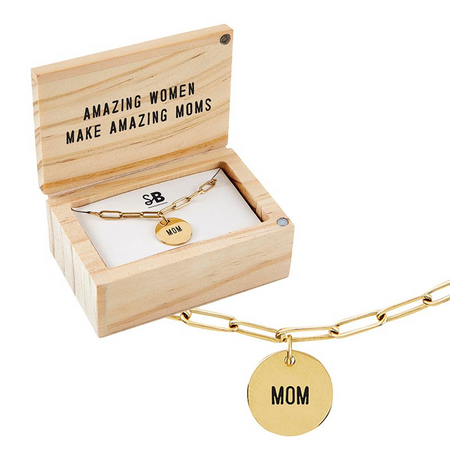 Gold bracelet with 'MOM' charm in a wooden box with 'AMAZING WOMEN MAKE AMAZING MOMS' text.