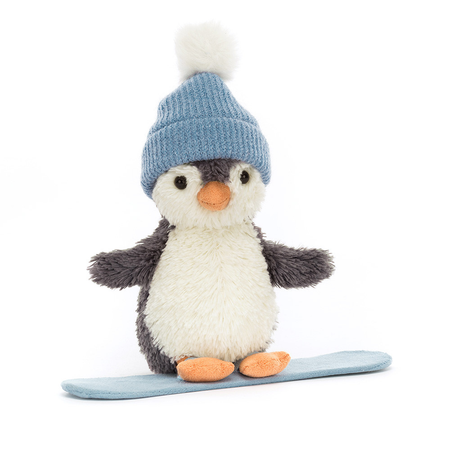 Stuffed penguin toy wearing a blue knitted hat on a snowboard with a white background