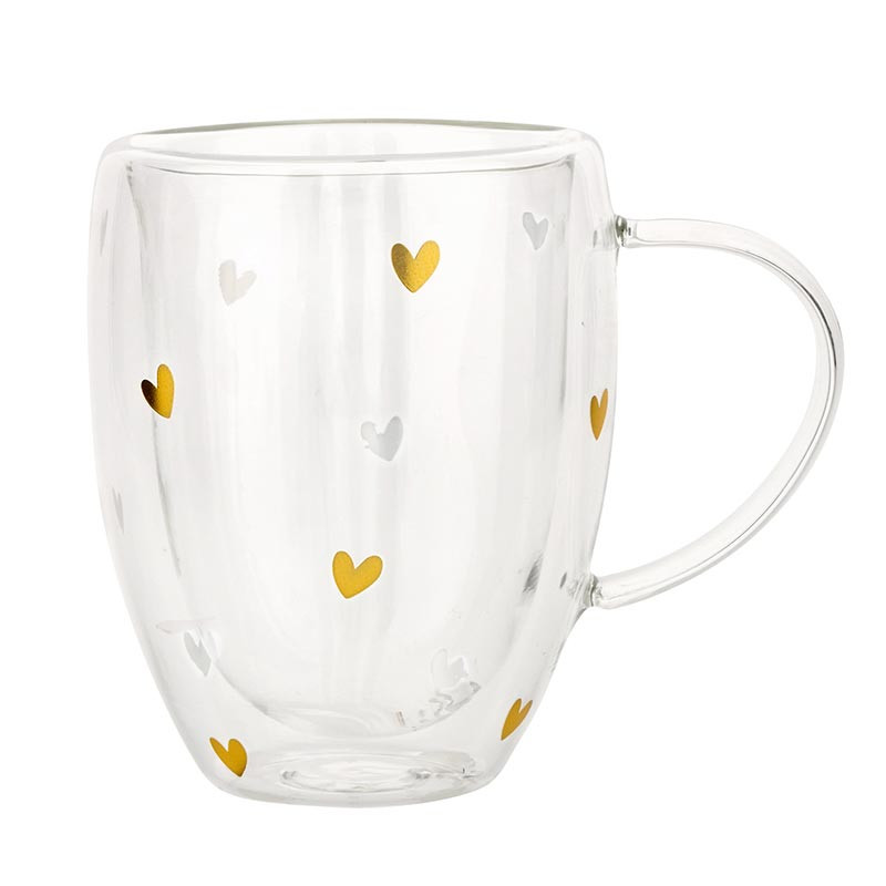 Clear glass mug with gold heart designs on a white background