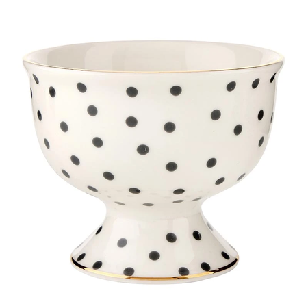 Decorative ceramic bowl with black polka dots and gold rim on a white background