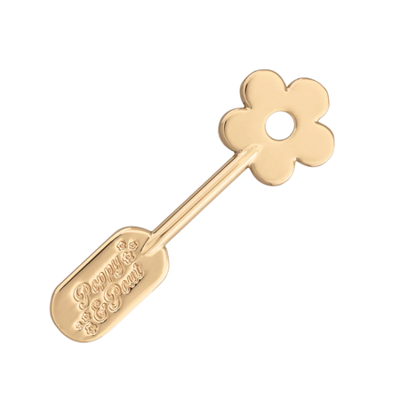 Gold flower-shaped ip care spatula on a white background