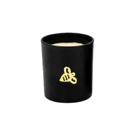 Black candle in a container with a yellow logo on a white background