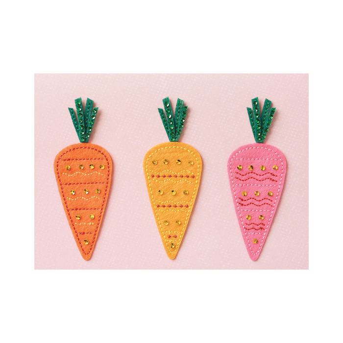 Three colorful carrot-shaped decorations on a pink card