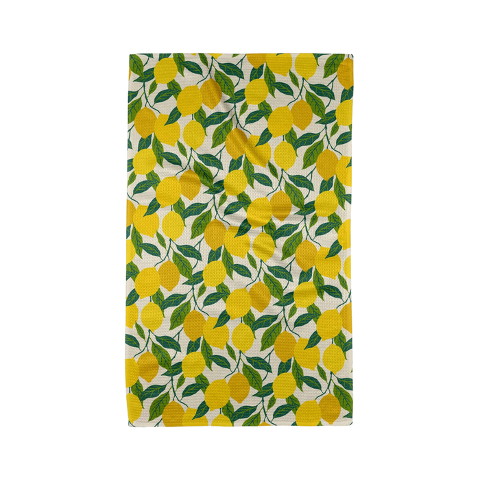 Patterned fabric with yellow lemons and green leaves on a white background