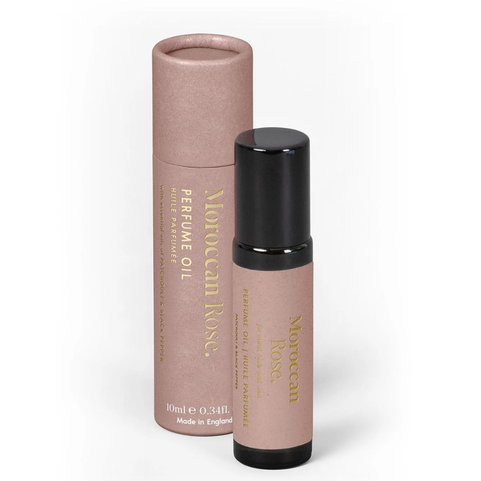 Perfume oil bottle and cylindrical container with 'Moroccan Rose' branding on a white background