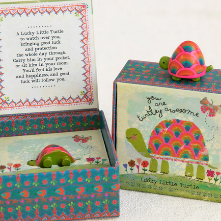 Colorful turtle-themed box with a small turtle lucky charm on a white background