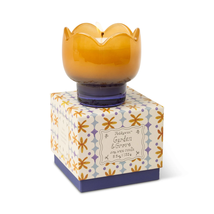 Yellow wax candle in a decorative box with floral pattern on a white background