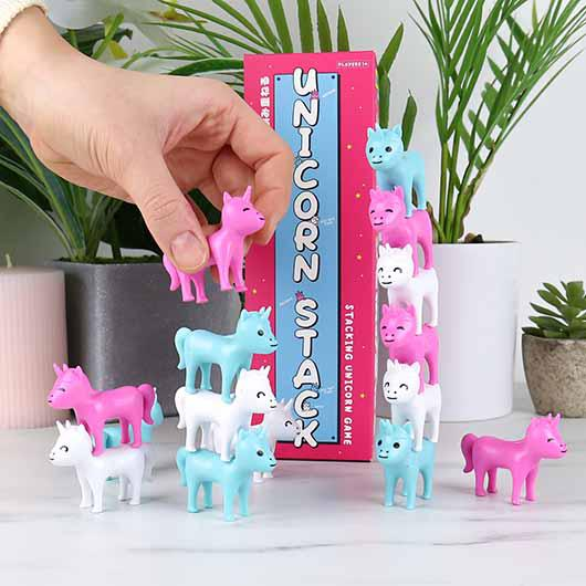 Stacking unicorn game with colorful unicorns and a pink box in the background.