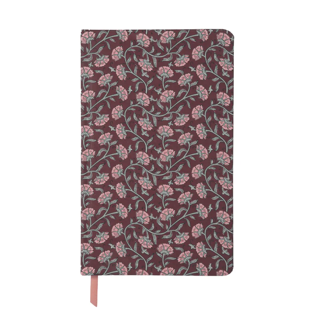A hardcover notebook with a dark burgundy cover featuring an all-over pink and sage green floral vine pattern, with a matching pink ribbon bookmark hanging from the bottom.
