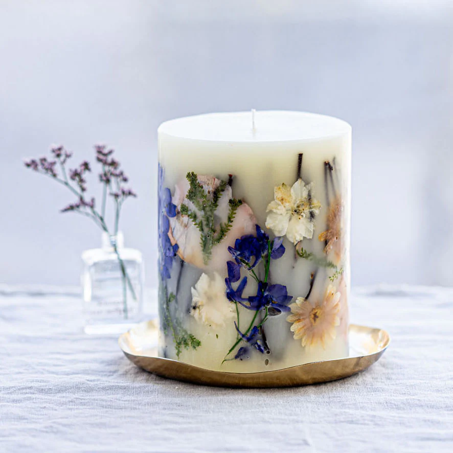 Decorative candle with floral design on a white surface