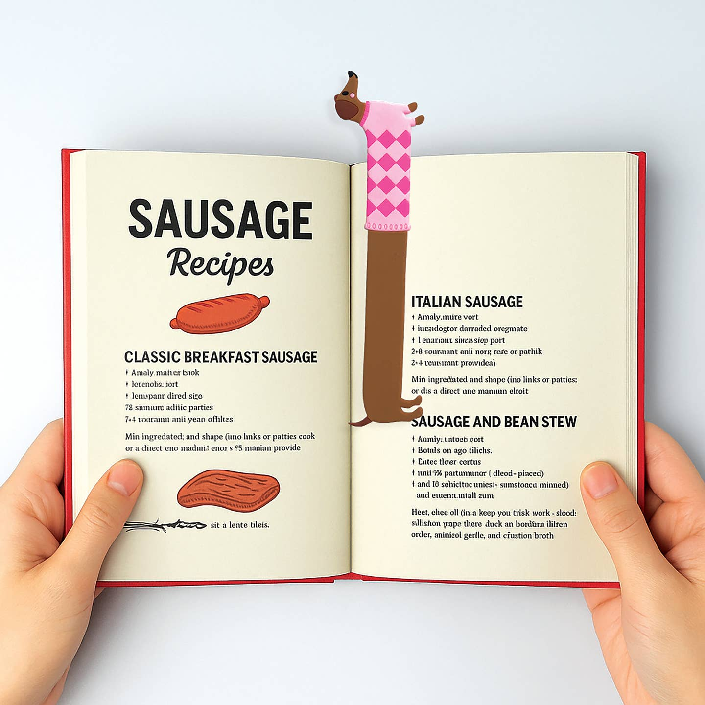 Open book with 'Sausage Recipes' section, held open by a sausage-shaped bookend with a pink argyle sock.