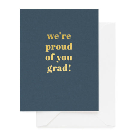 Navy blue card with gold text 'we're proud of you grad!' and a white envelope.