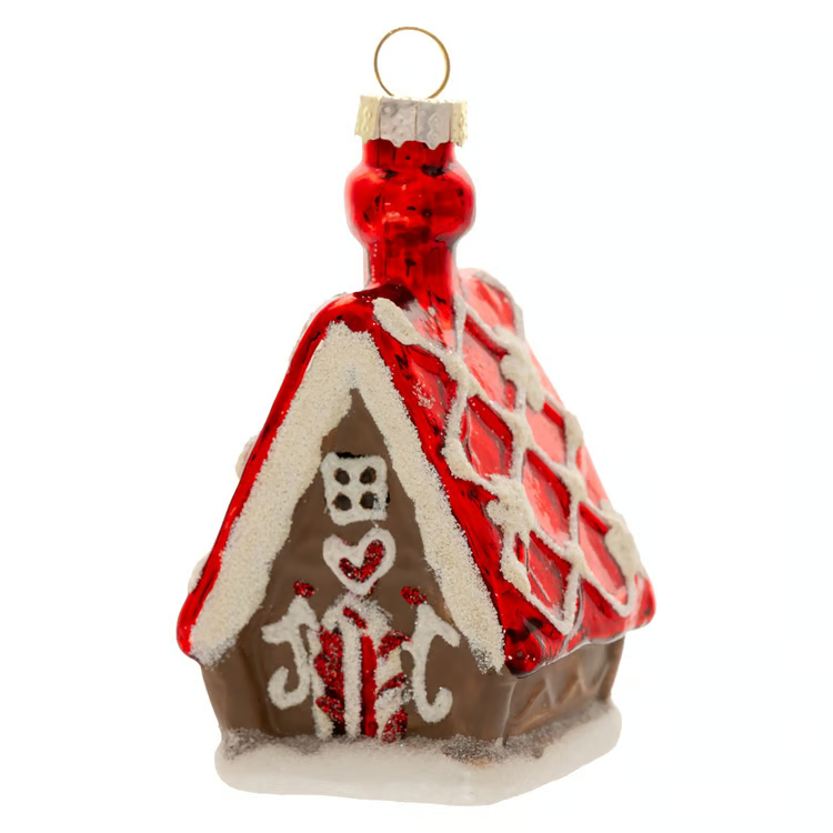 A gingerbread house Christmas ornament with a red glittery roof, white icing-style trim, a brown body, and a gold hanging loop on a white background.