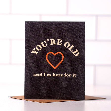 Greeting card with text 'You're old and I'm here for it' on a black background