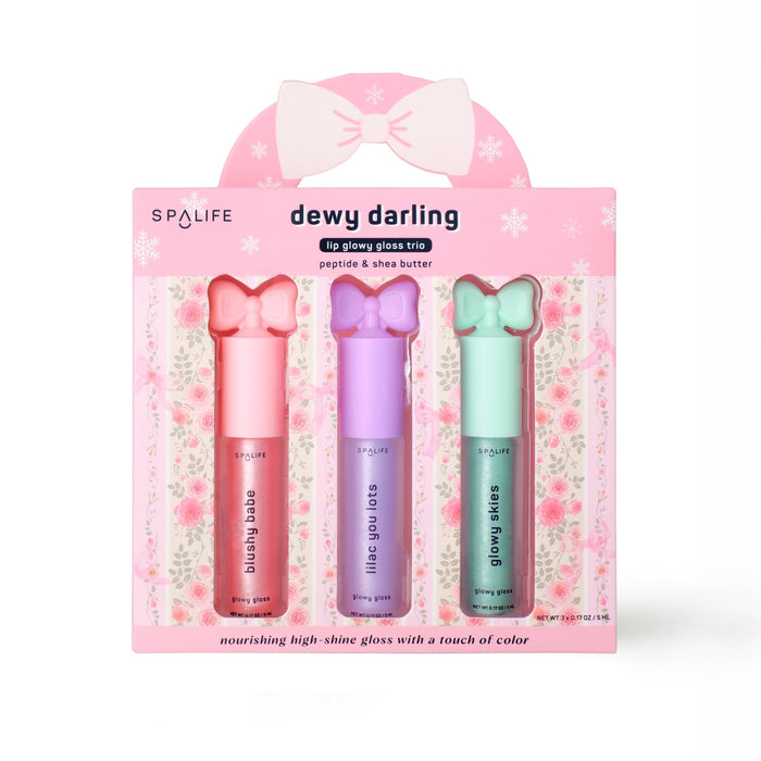 Spa Life dewy darling lip gloss trio packaging with three lip glosses in pink, purple, and green on a floral background.