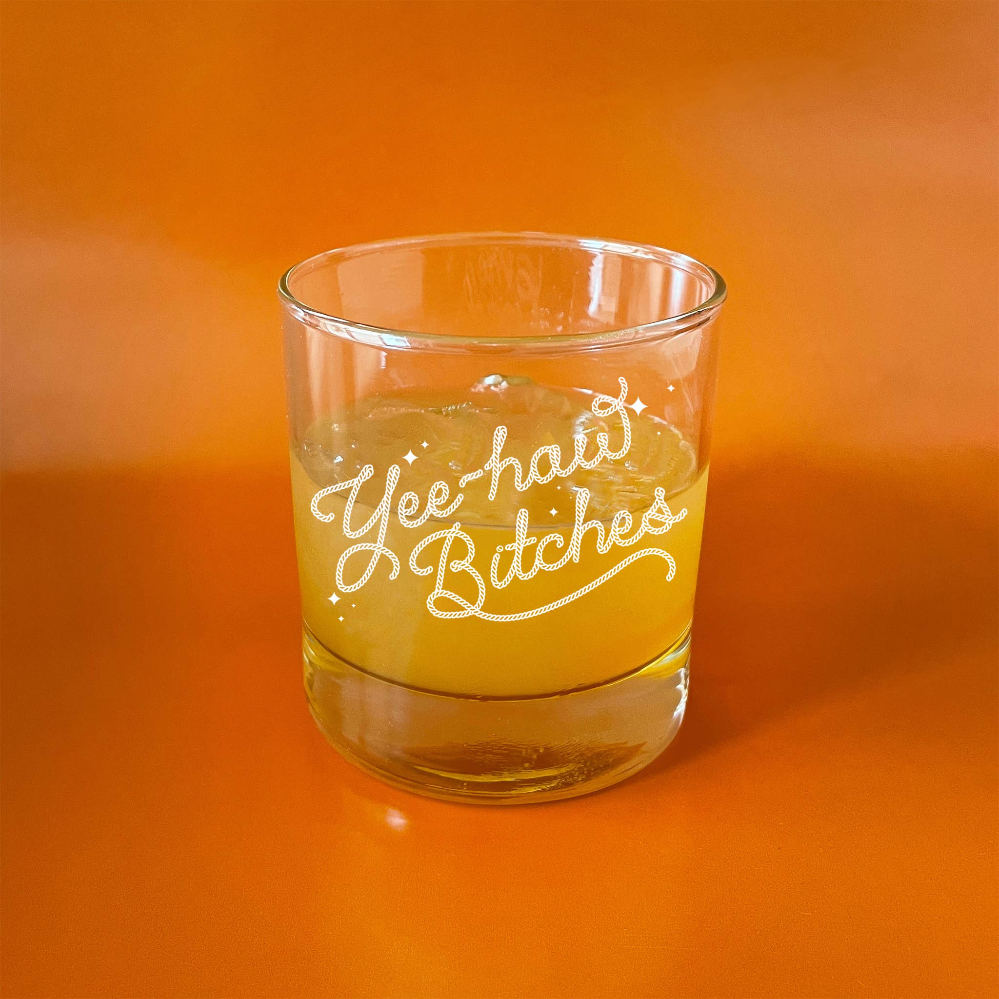 Glass featuring text that reads 'Yee haw Bitches' on an orange background