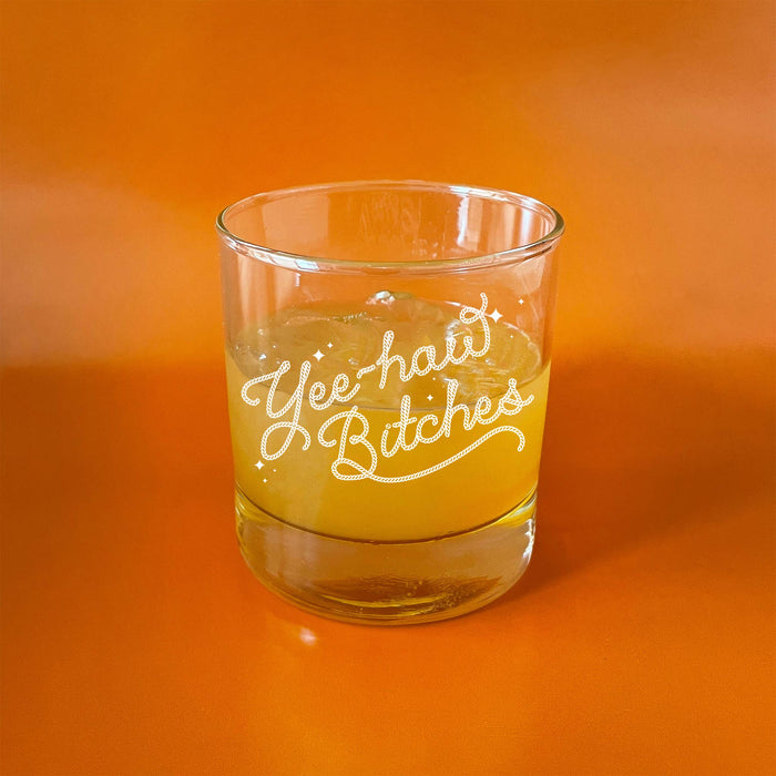Glass featuring text that reads 'Yee haw Bitches' on an orange background