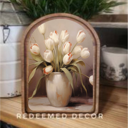 Decorative vase with tulips inside a wooden frame on a table, with 'Redeemed Decor' branding.